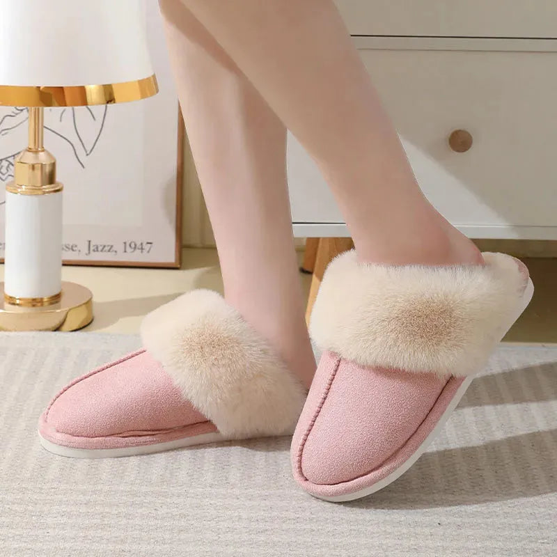 Women's brown plush indoor slippers with round toe, flat heel, and decorative stitching.