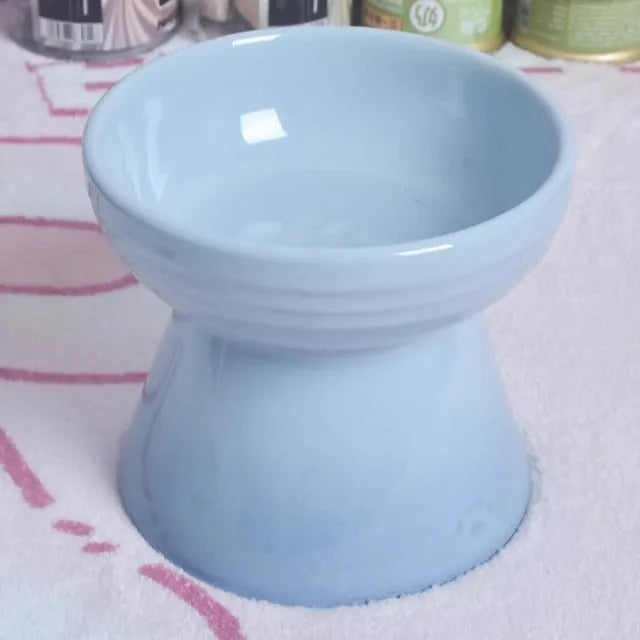 A white ceramic pet bowl with a high foot and raised neck protector to prevent tipping.