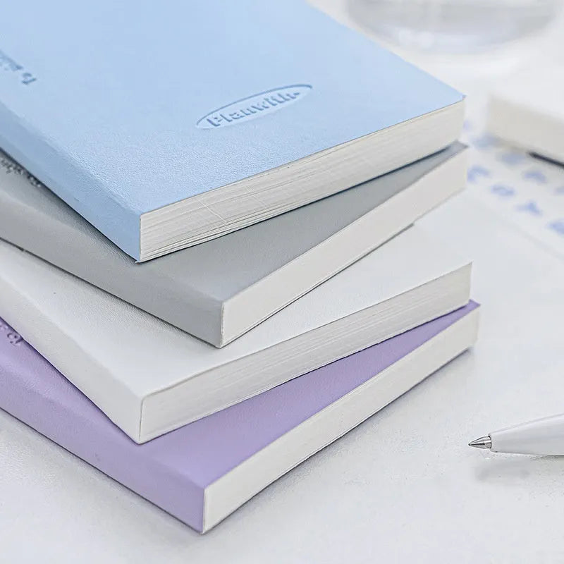 Embossed cover daily meter book notebook open on a desk, showing white 100g paper.
