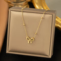 Gold bow necklace with cross chain design showing adjustable length from 41 to 50cm