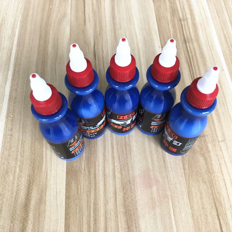 Small blue automotive scratch repair agent bottle with wiping tool for car paint scratch removal