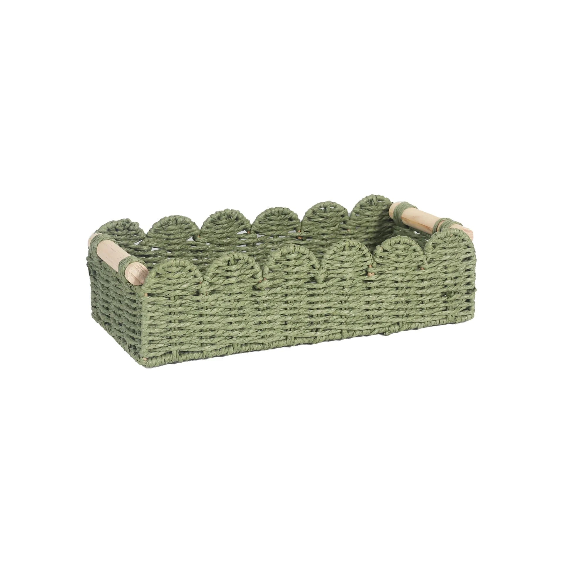 Modern woven paper storage basket in khaki colour on a wooden desktop, holding remote controls and pens.
