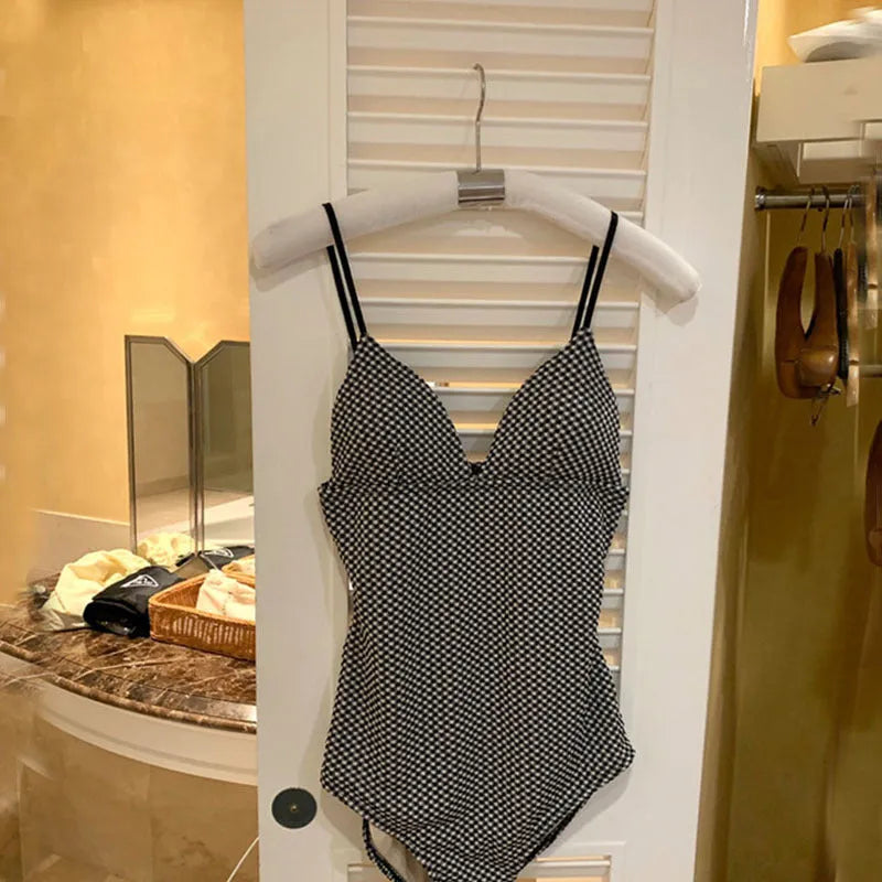 A black or blue one-piece swimsuit with a cover-belly design for a thinner body type.