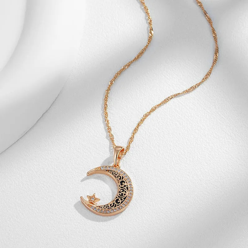 Rose gold-tone moon and star pendant necklace with enamel details on a water wave chain.