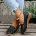 Women's flat slip-on loafers in PU leather with car stitch detail and a round toe, shown on a white background.