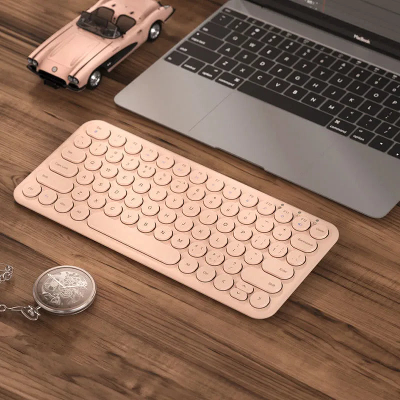 Ultra-thin white wireless keyboard and mouse set with USB receiver on a wooden desk.