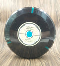 Black AC automatic sweeping robot vacuum cleaner on a wooden floor.
