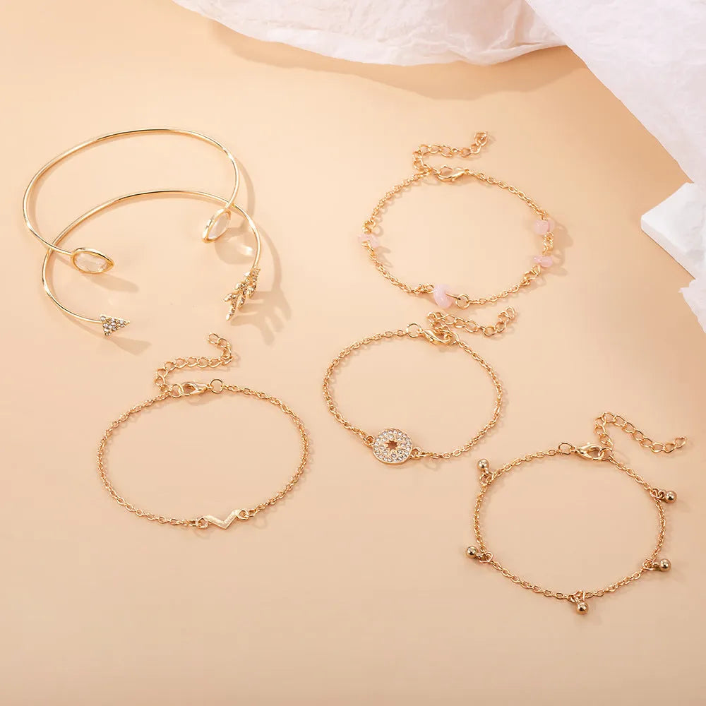 Gold-coloured zinc alloy bracelet set with arrow, water droplet, and V-shaped charms