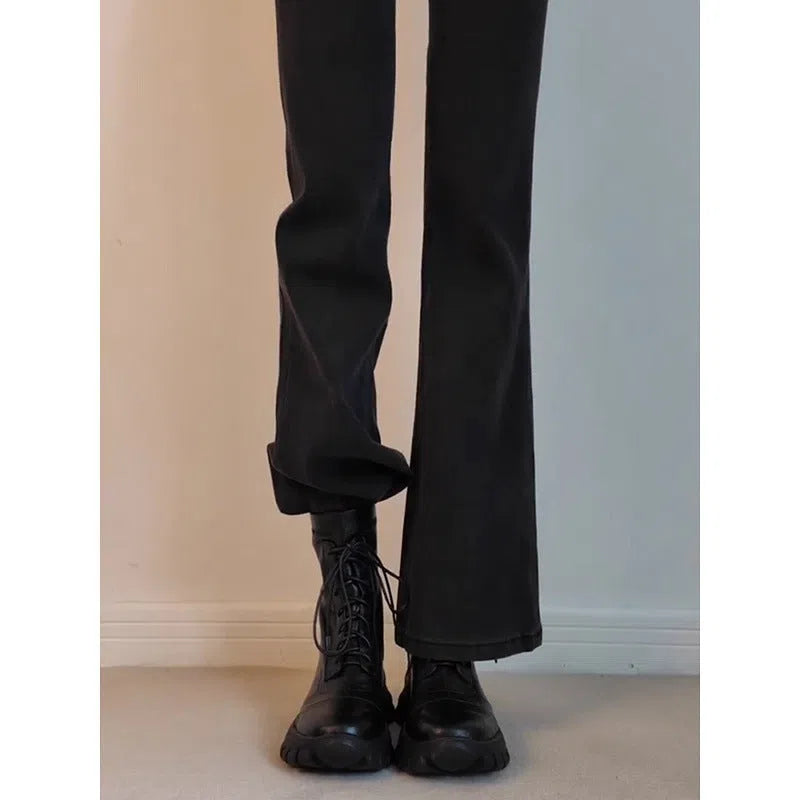 Black thick-soled motorcycle boots with back zipper and lace-up closure on a grey background