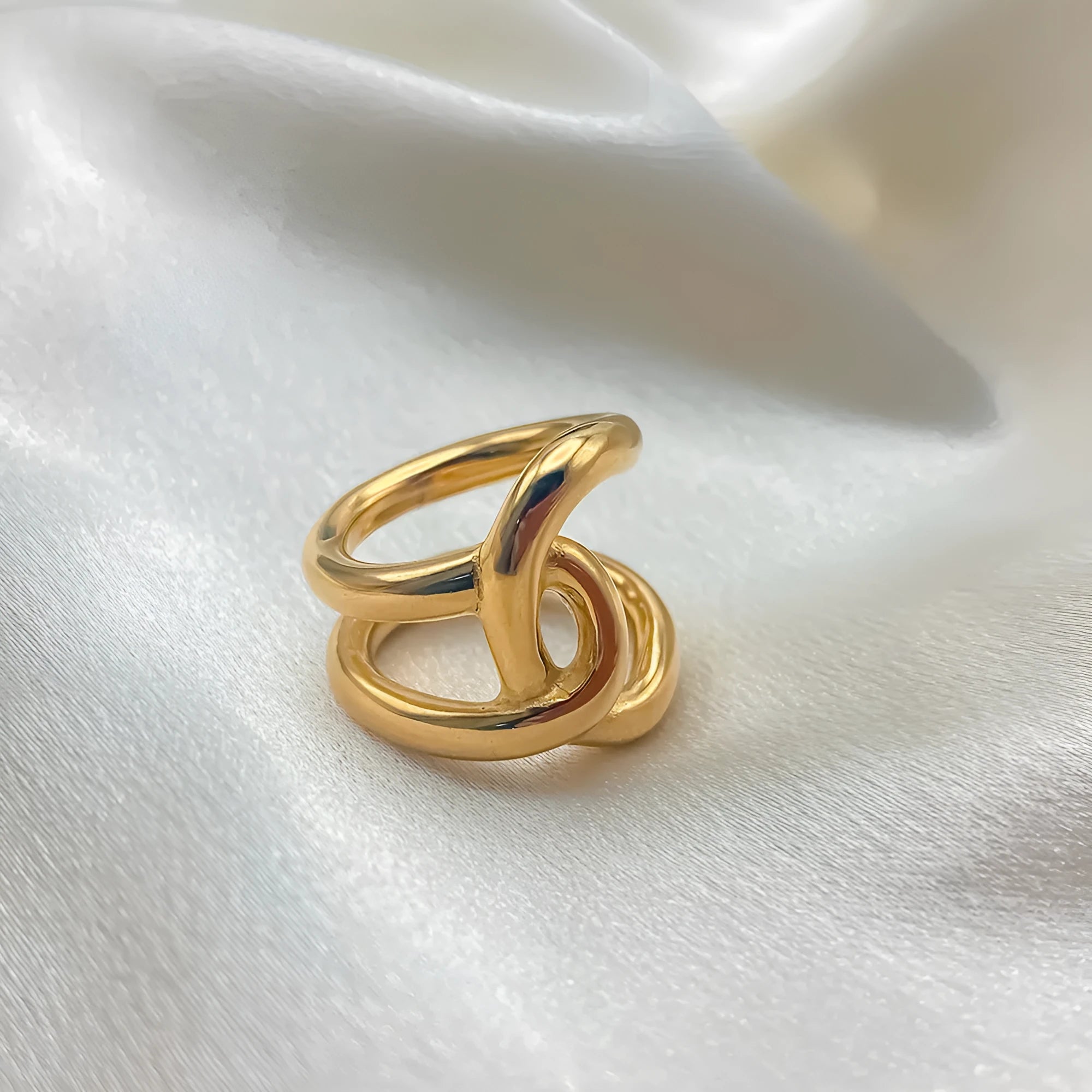 Adjustable stainless steel ring for women with a knotted geometric U-shape design in gold or silver tone.
