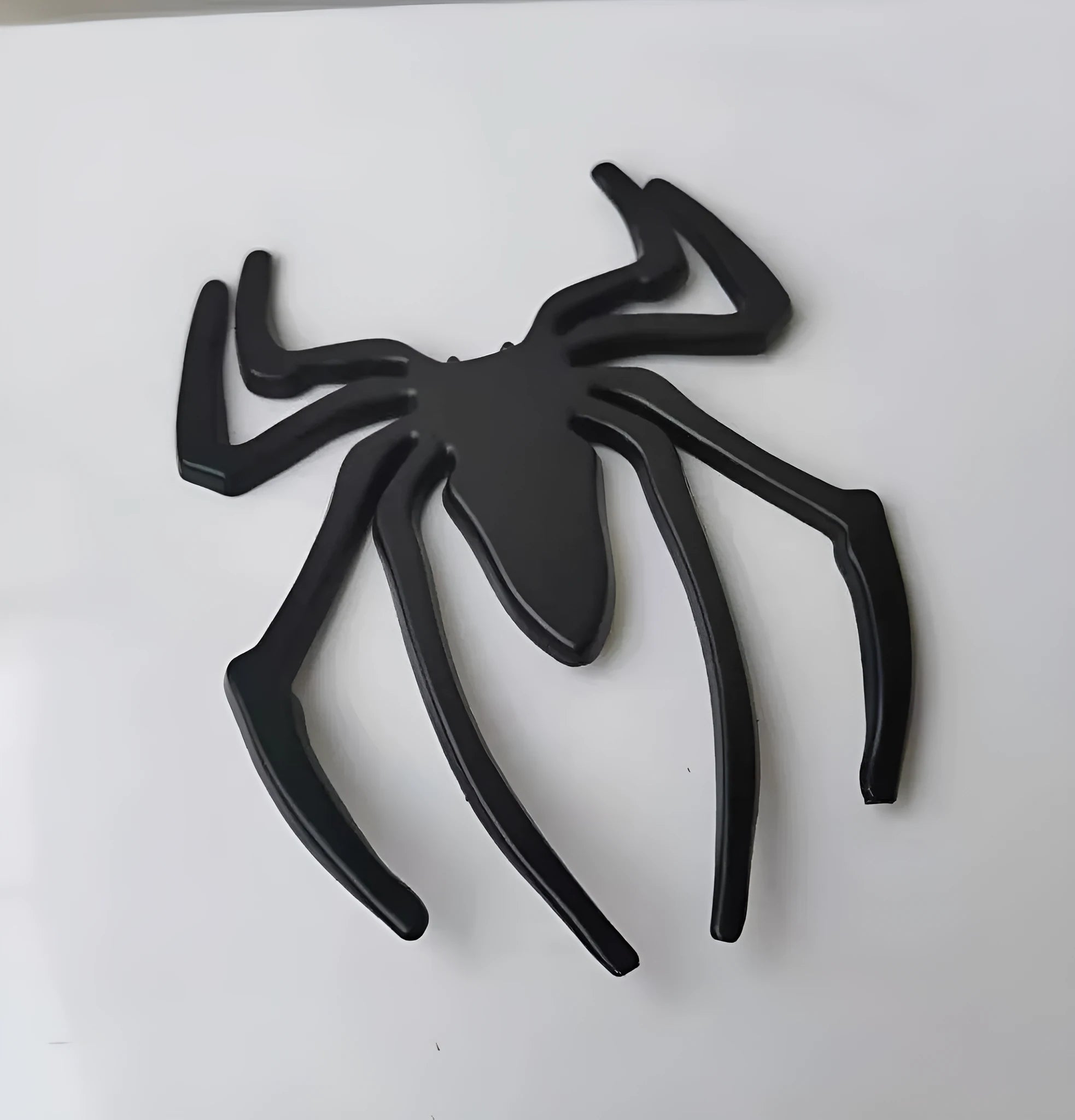 Three-dimensional metal spider sticker in gold colour, measuring 7cm by 5cm.