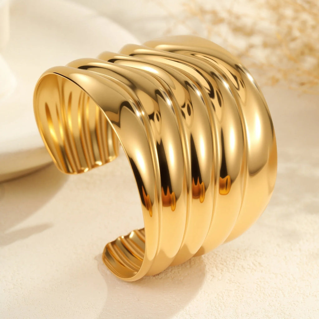 Women's wide fashion bracelet with wave design in gold-plated stainless steel