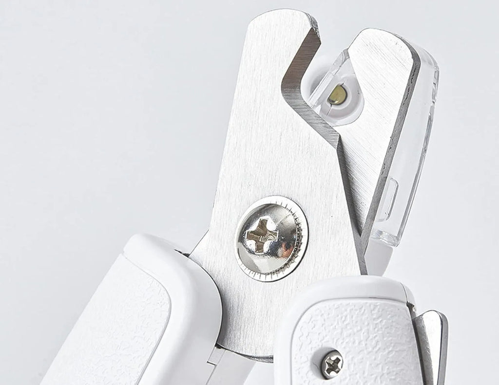 White pet nail clippers with LED light, transparent anti-splash baffle, and a nail file.