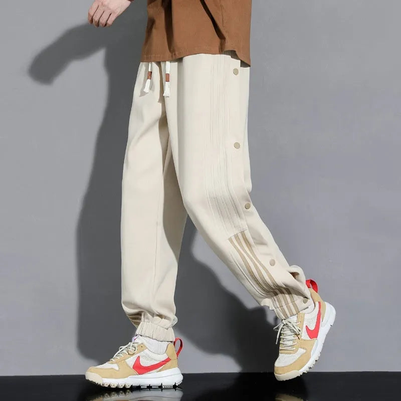 Men's black loose-fit sweatpants with ankle ties and a drawstring high waist on a neutral background.