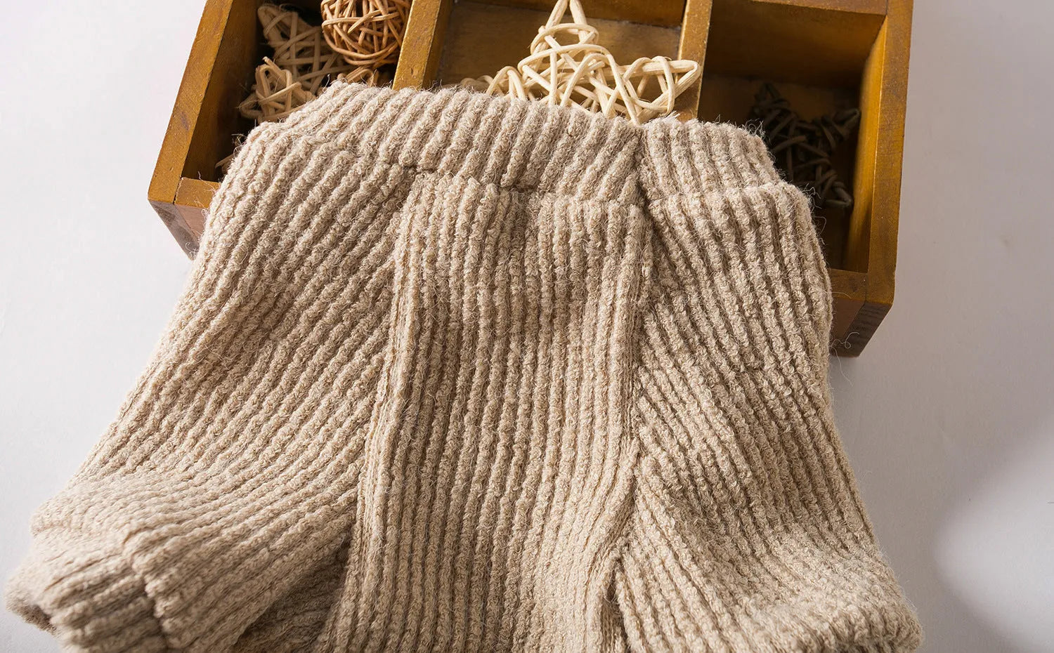 Brown knitted pullover sweater on a small dog, showing four-leg design for full coverage.