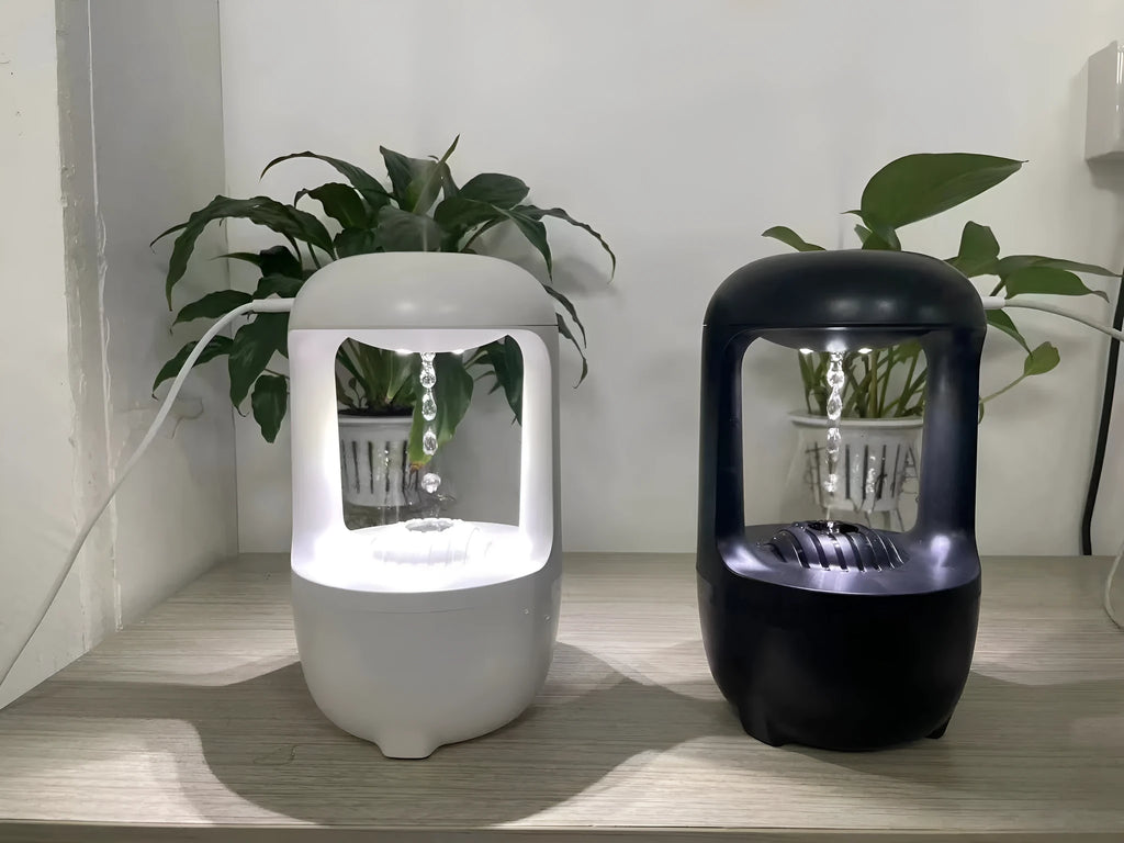 White anti-gravity water droplet humidifier on a table with USB cable, showing mist output