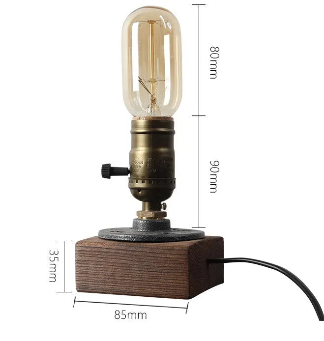 Industrial-style wooden and iron water pipe table lamp on a surface, showing its compact size.