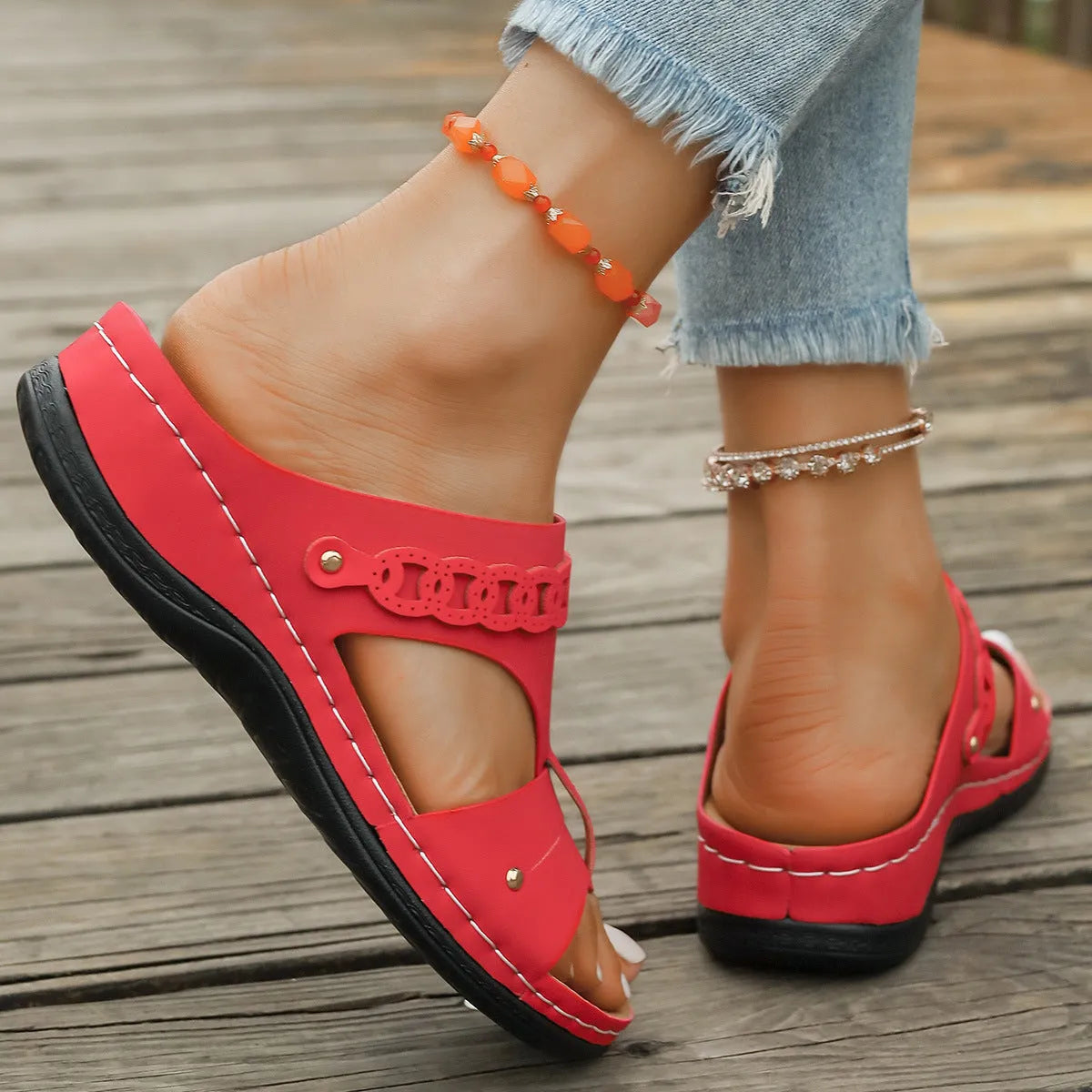 A pair of slope heel Roman style slippers with a fish mouth toe holder, shown in one of six available colours.