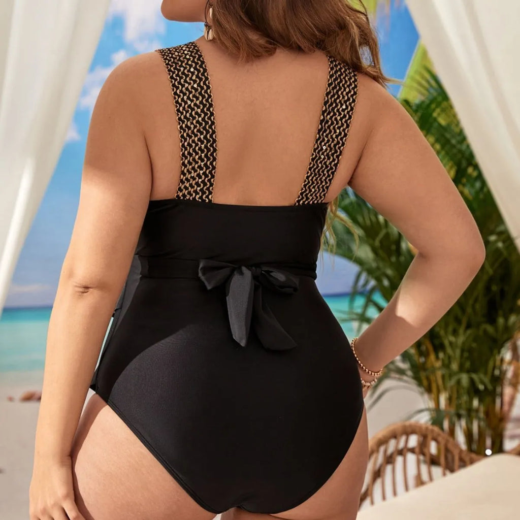 Women's black plus size one-piece swimsuit with removable chest pads on a hanger.
