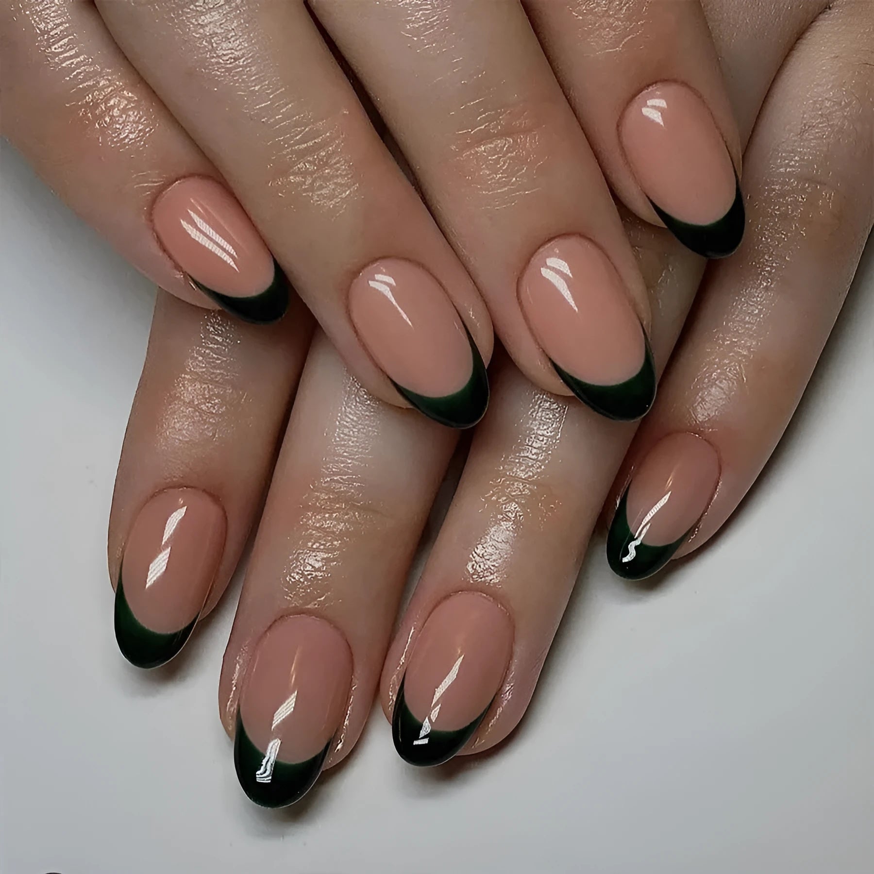 Set of 24 short almond-shaped false nails in a simple black French style design on a white background.