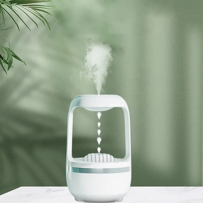 White anti-gravity water droplet humidifier on a table with USB cable, showing mist output
