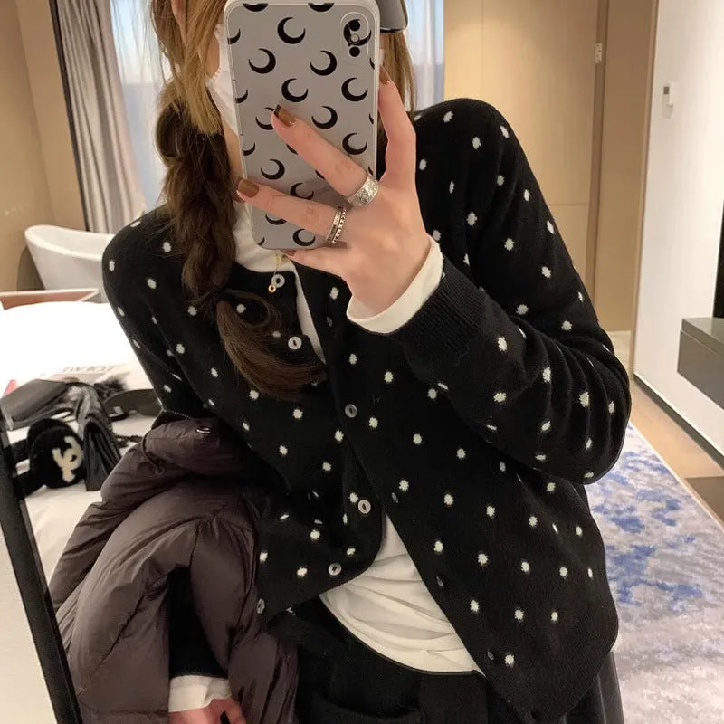 Grey dot knitted women's cardigan with crocheted flower details on the front.