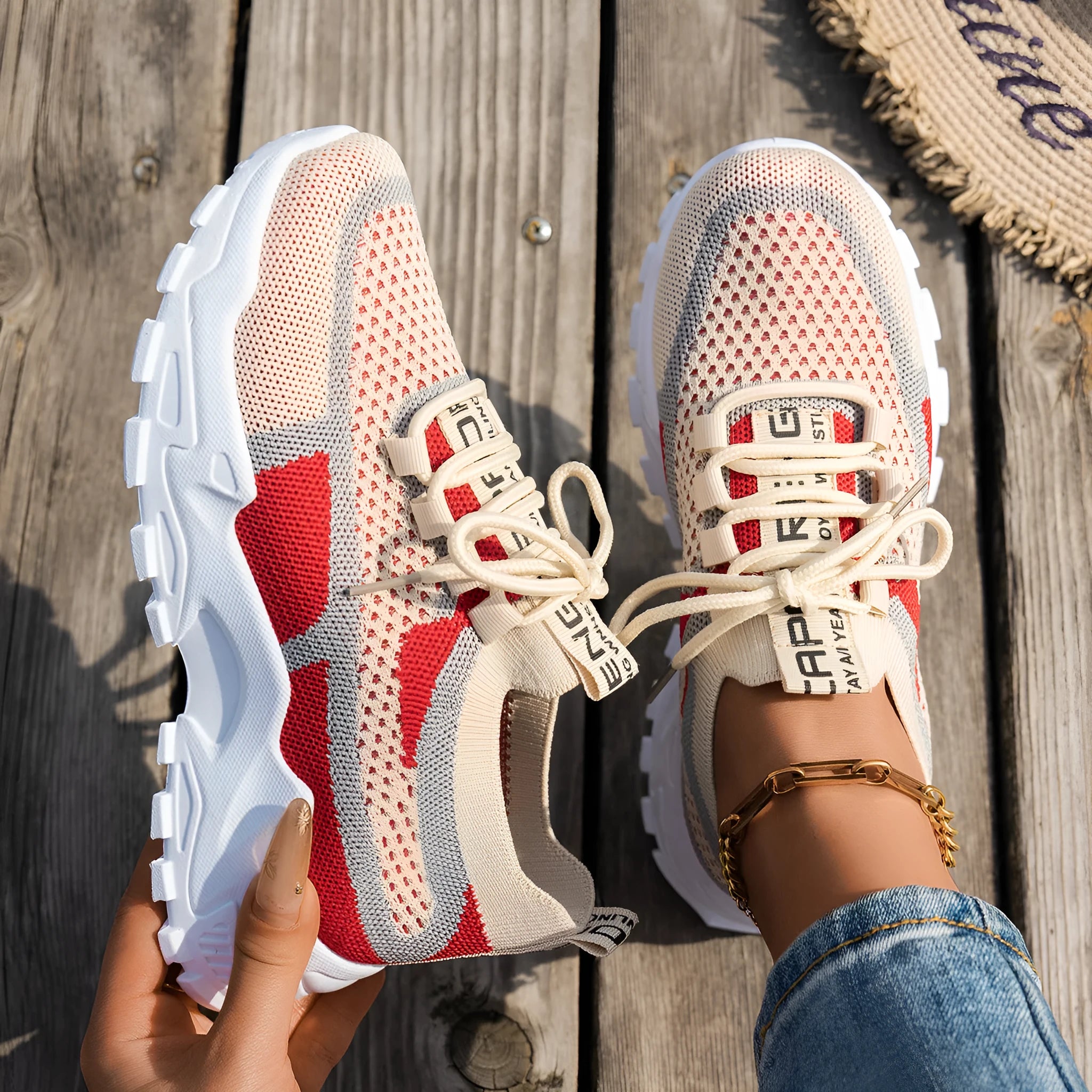 Women's Flyknit mesh sneakers in grey and white colour with flat rubber sole and lace-up front.