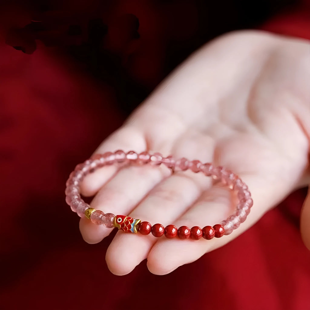 Close-up of a women's purple cinnabar and strawberry quartz lucky bead bracelet in a retro style.