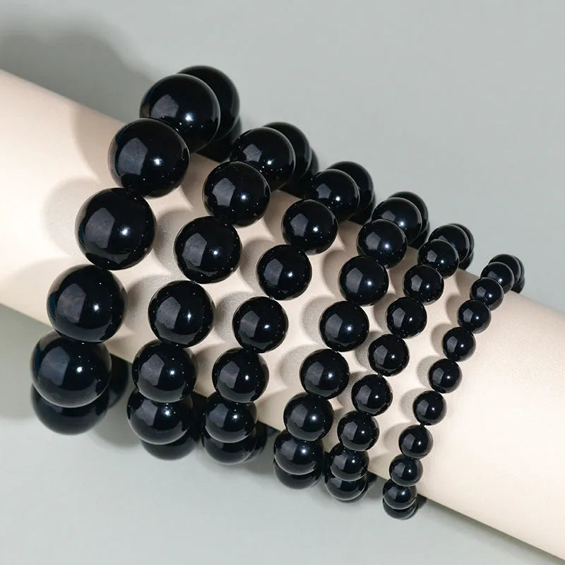 Hand-woven obsidian couple bracelet showing spherical black crystal beads in continuous strand construction