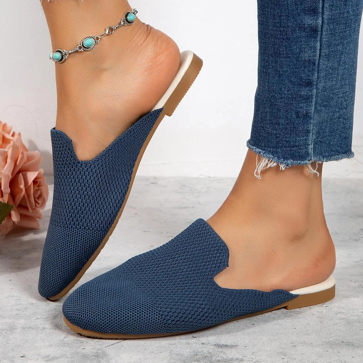 A pair of apricot-coloured mesh slip-on sandals with a cloth upper and flat rubber sole.