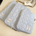 White cotton notebook storage bag with blue cloud embroidery on a table