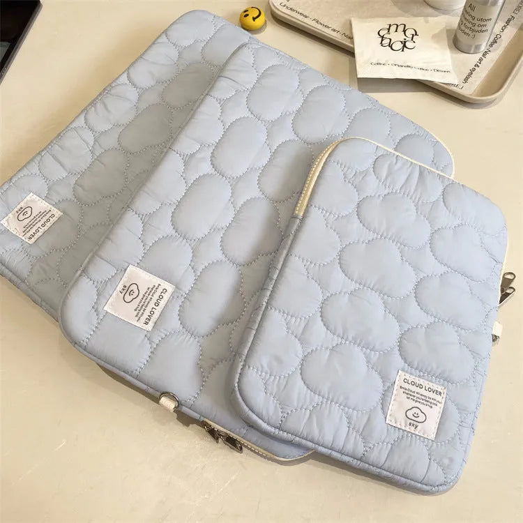 White cotton notebook storage bag with blue cloud embroidery on a table