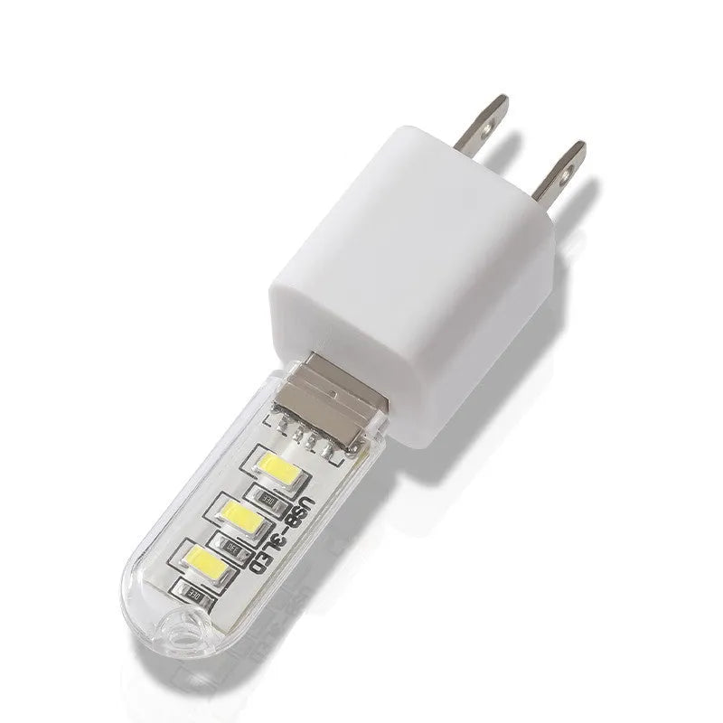 Compact round white LED night light with USB cable, shown with warm and white light illumination.