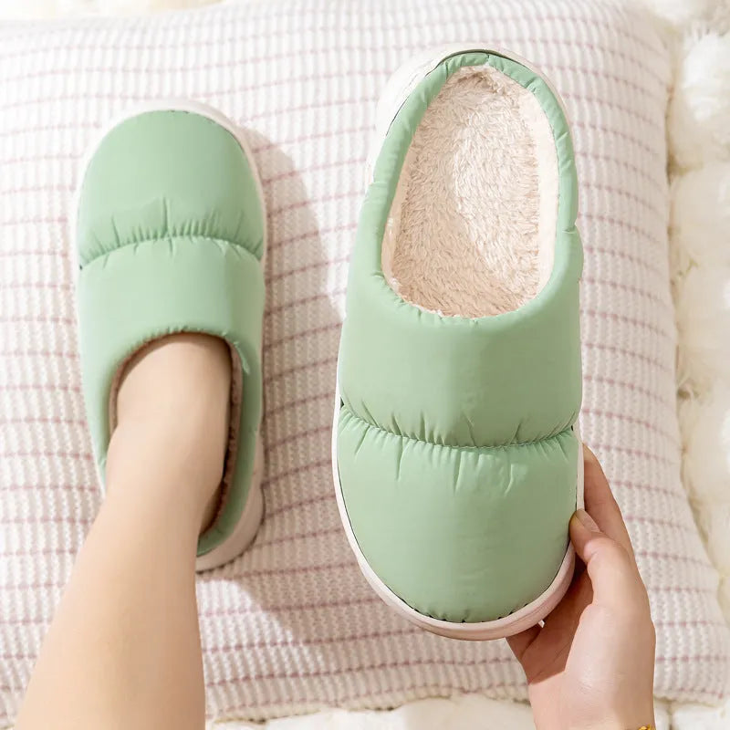 Pair of down cotton indoor slippers with artificial leather upper and thick rubber sole.