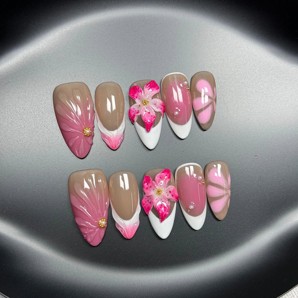 Set of French style artificial nails with white tips and 3D white lily flowers on almond-shaped plastic nail tips.