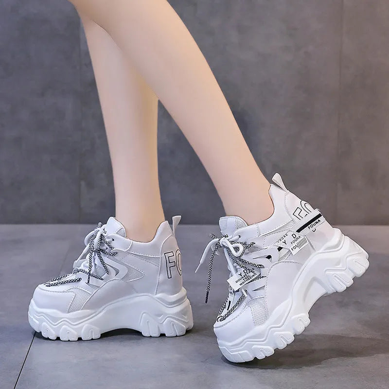 Women's white and black mesh platform sports shoes with cross-strap and rubber sole.