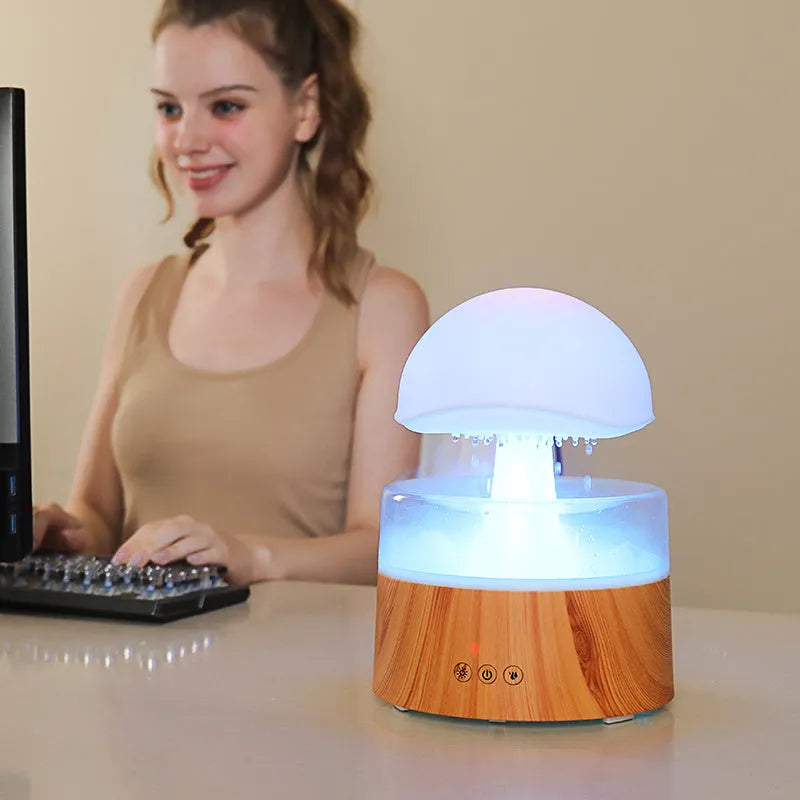 White cloud rain humidifier with rainfall simulation and LED lighting on wooden surface