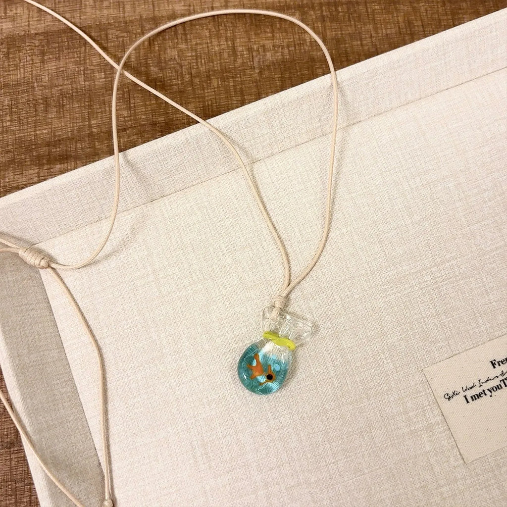 Women's necklace with a coloured glaze skirted joker pendant on a cotton and linen clavicle chain.