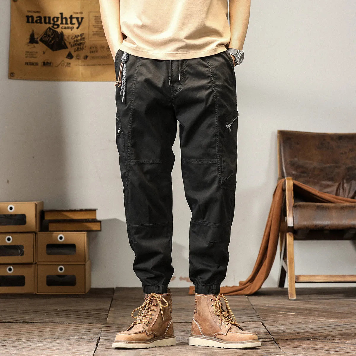 Men's khaki cotton tapered harem pants with ankle bands and a zip fly, laid flat.