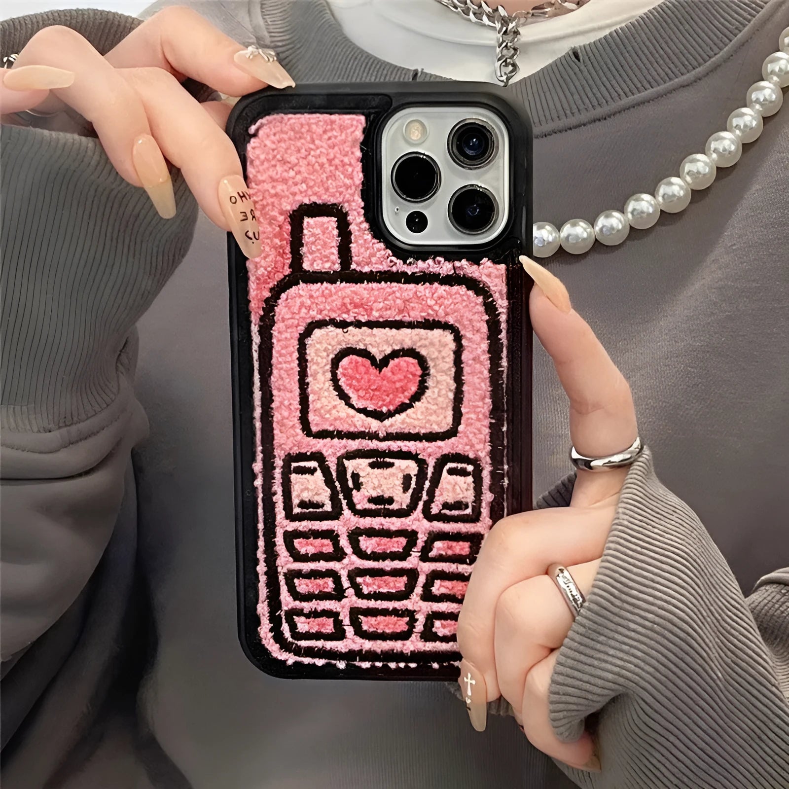 Soft pink TPU iPhone case with a towel-like embroidered texture on the back.