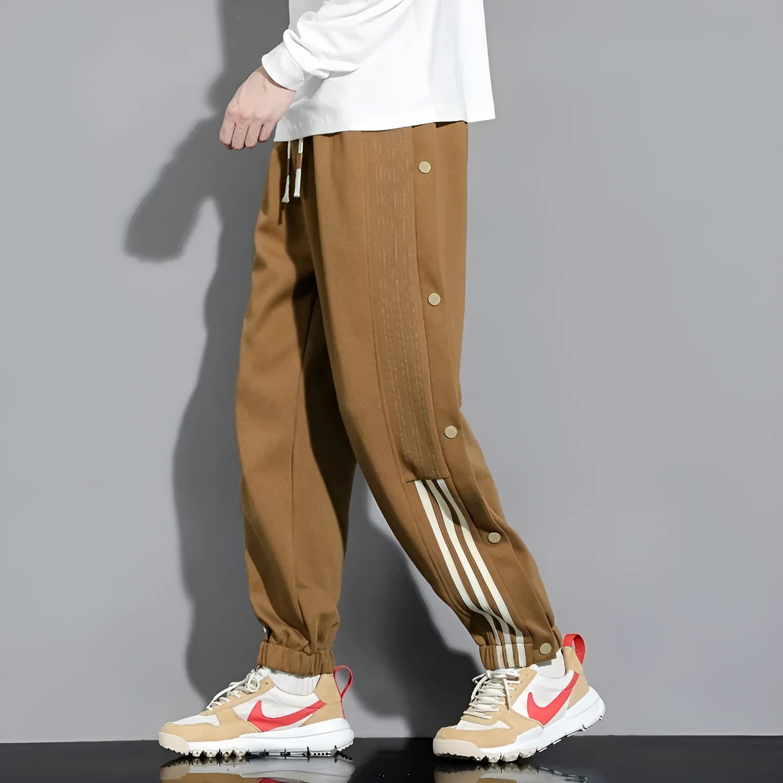 Men's black loose-fit sweatpants with ankle ties and a drawstring high waist on a neutral background.