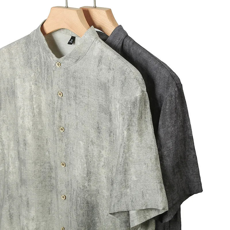 Man wearing a loose grey linen shirt with a stand collar and short sleeves, cardigan style.