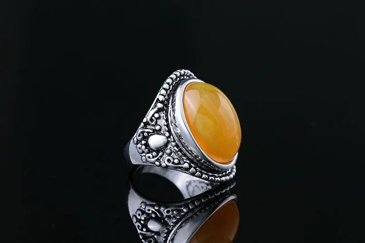 Close-up of a geometric retro ring in antique silver amber with a beeswax fluorescent finish.