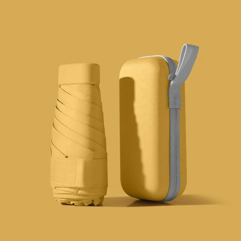 Ultra-light six-fold sun umbrella open, showing NC fabric canopy and rubber handle, next to its compact folded size in a capsule box.