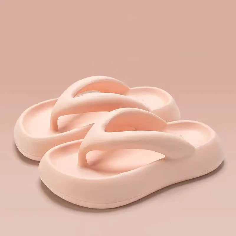 A pair of thick-soled flip-flops with a bow detail on the upper, shown in a solid colour.