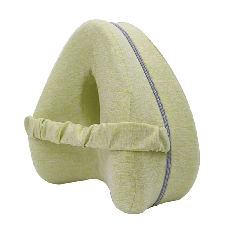 Heart-shaped dark blue memory foam leg pillow for adults on a bed