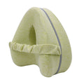 Heart-shaped dark blue memory foam leg pillow for adults on a bed