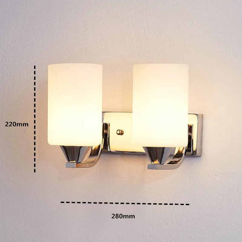 Modern chrome-finished wall lamp with a clear glass shade, shown in a single head configuration.
