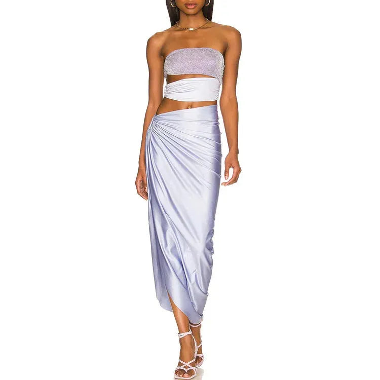 Purple one-piece swimsuit and matching wrap skirt set laid flat.