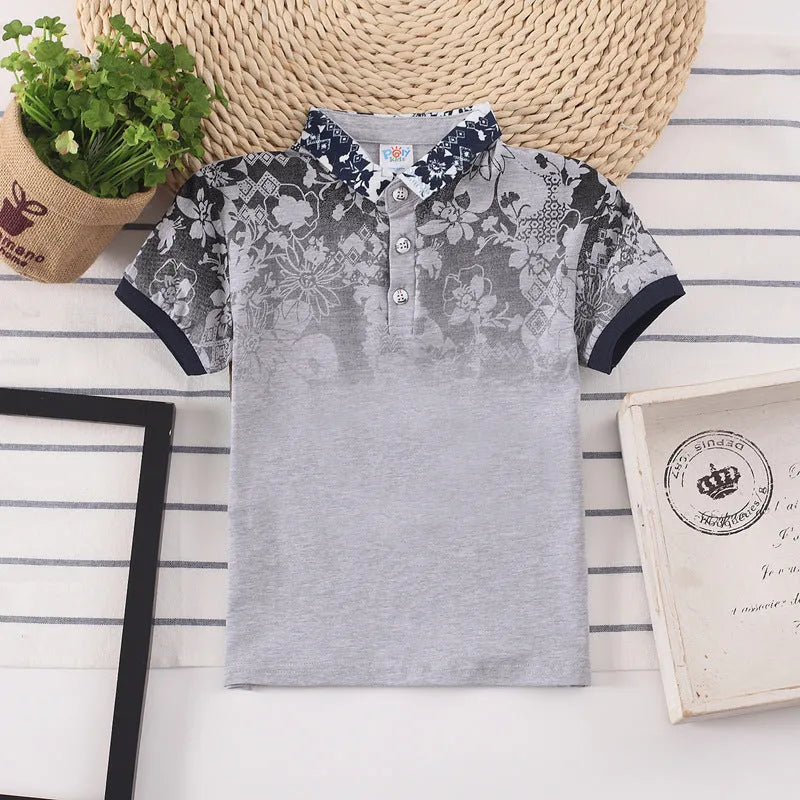 Boys short sleeve cotton T-shirt in navy blue with a lapel collar, laid flat.